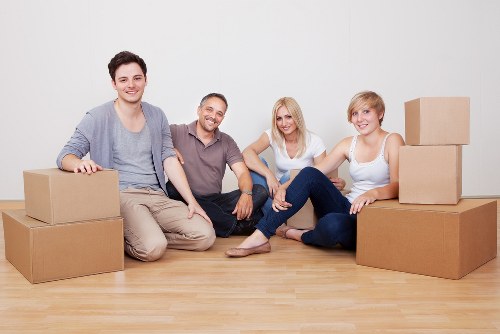 Movers carrying household furniture through a Brent property entrance